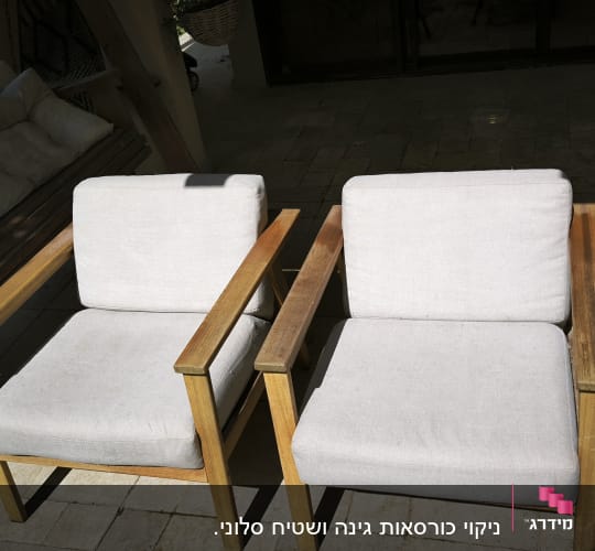 שני כיסאות עץ עם ריפוד בהיר בחוץ
